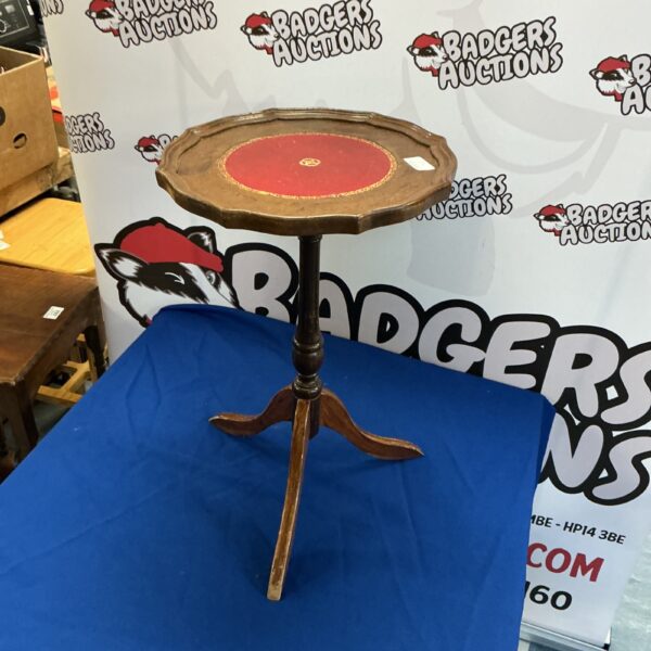 Antique wine table with a circular leather top and tripod base.