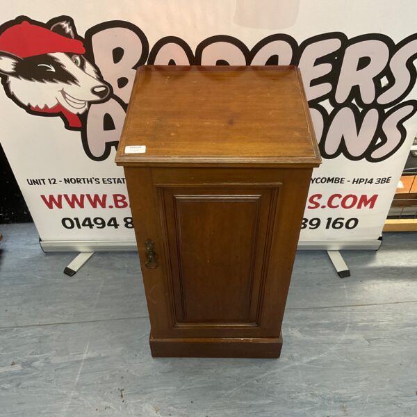 Antique wooden bedside cabinet with decorative moulding.