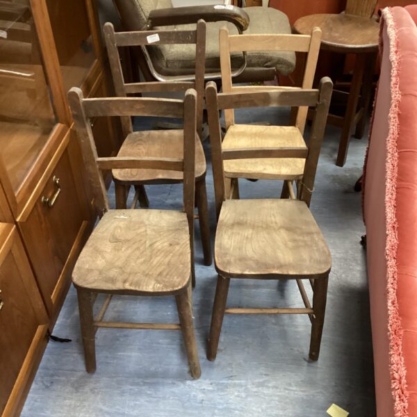 Set of four antique wooden chairs with farmhouse style.