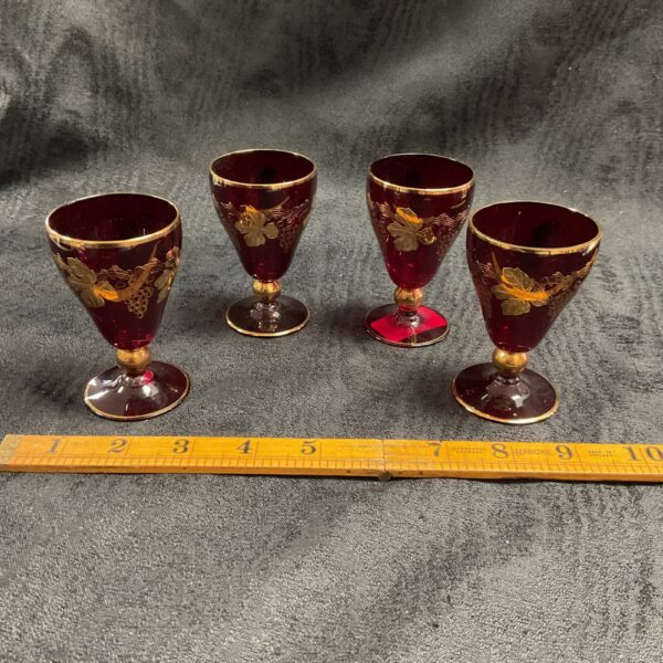 Set of four vintage Art Deco wine glasses with ruby glass and gold rims.