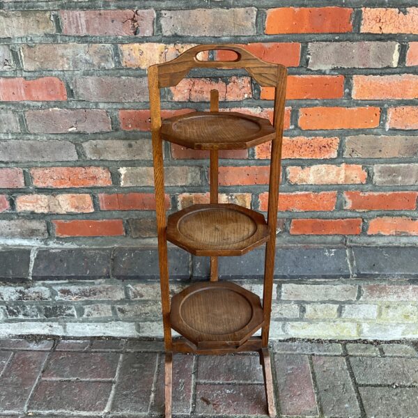Antique Arts and Crafts oak three-tier stand for display.