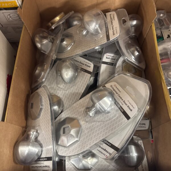 Box of assorted new door handles for interior doors.