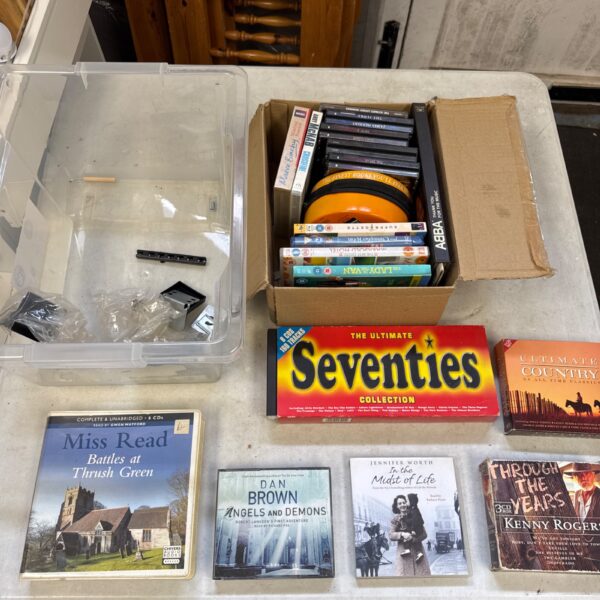 Mixed lot of audio books, CDs, and DVDs for entertainment.
