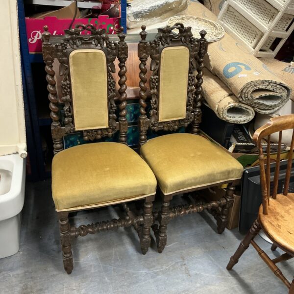 Pair of antique Baroque dining chairs with carved wood frames.