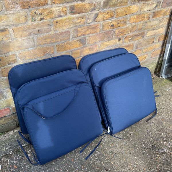 Four blue garden chair cushions for outdoor seating comfort.