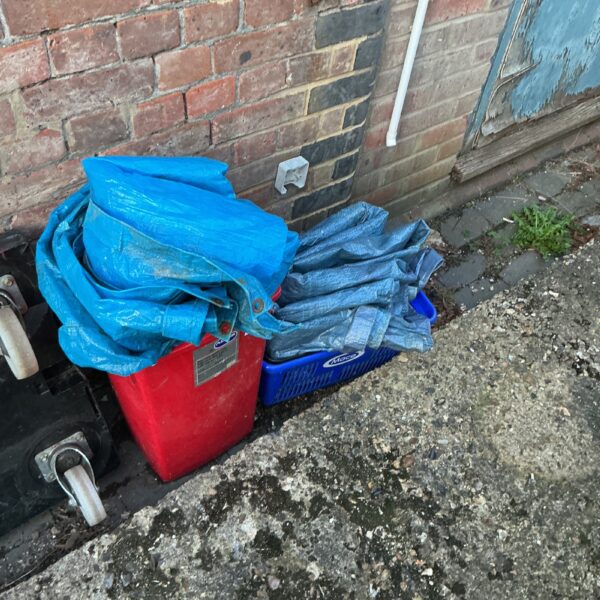 Blue and grey tarpaulins stored in a red container.