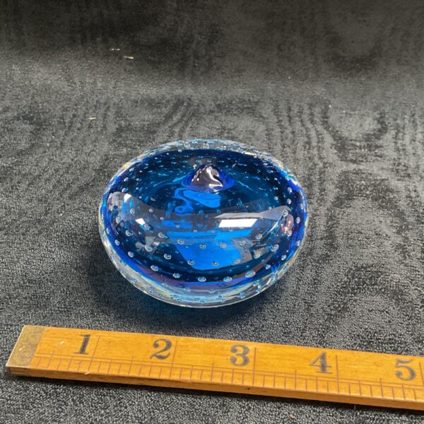 Vibrant blue Murano style glass paperweight with bubbles.