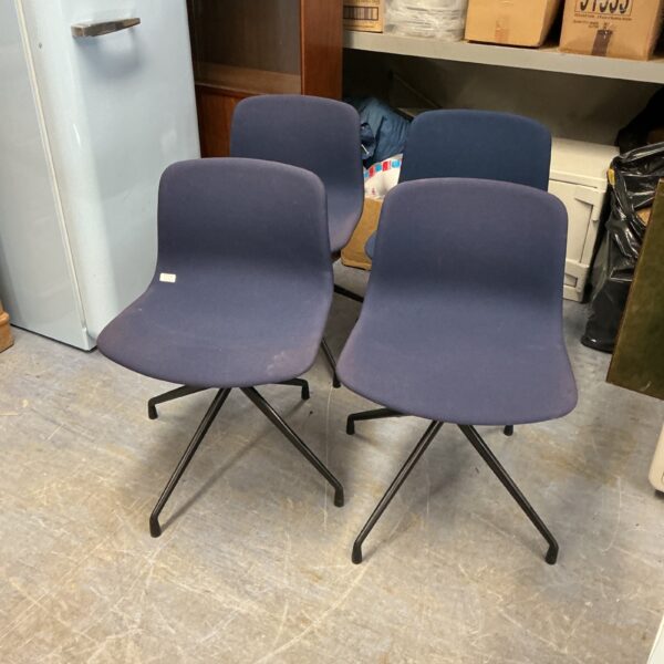 Set of four blue reception chairs in an office setting.