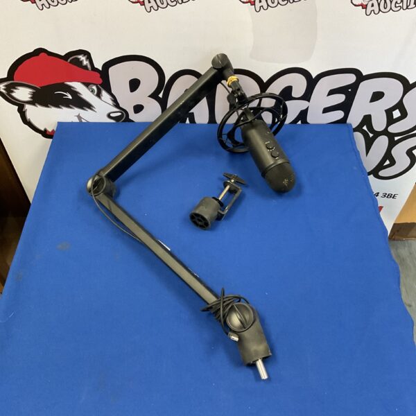 Blue studio microphone boom arm on a desk.