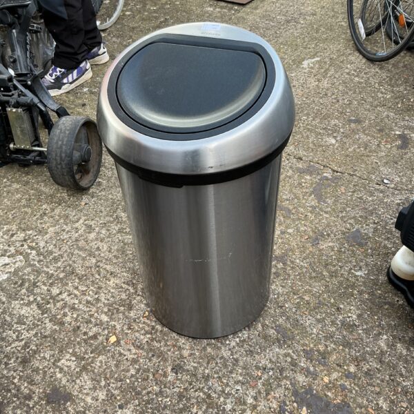 Stainless steel Brabantia bin with pedal mechanism in a kitchen setting.