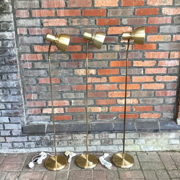 Set of three vintage brass floor lamps with adjustable shades.