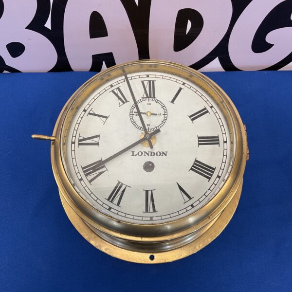 Vintage brass ships clock with Roman numerals, nautical timepiece.
