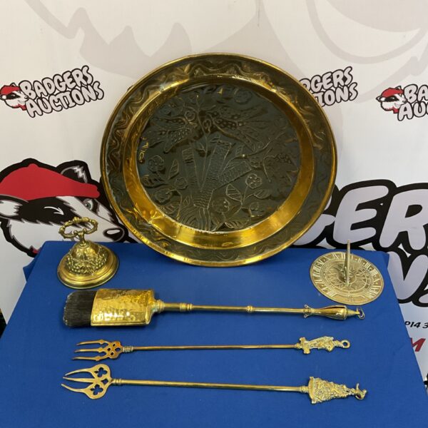 Intricate brass tray with fireplace tools and sundial in a collection.