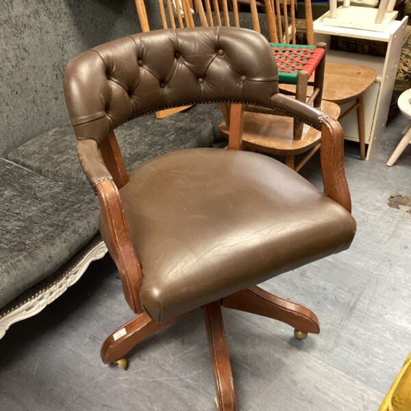 Vintage brown leather captains chair with swivel base.