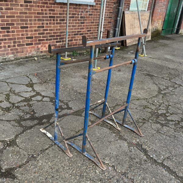 Pair of blue metal builders trestles for construction support.