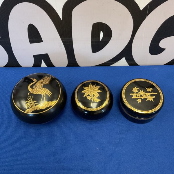 Vintage Burmese lacquerware nesting pots with gilded floral designs.