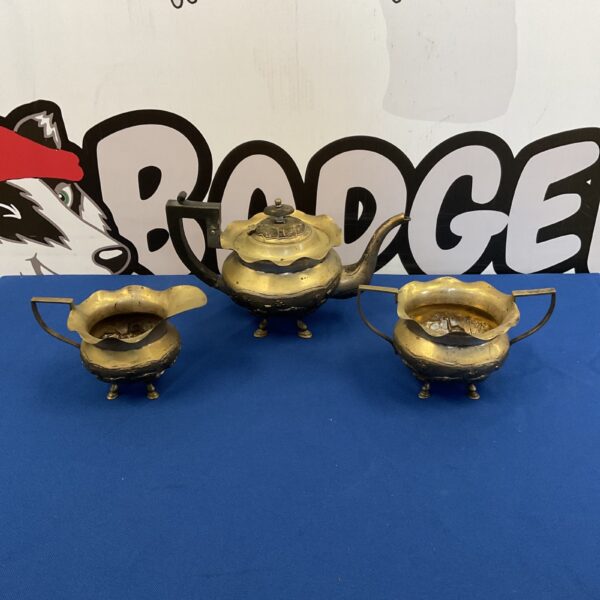 Full view of antique Burmese silver tea set on blue background.