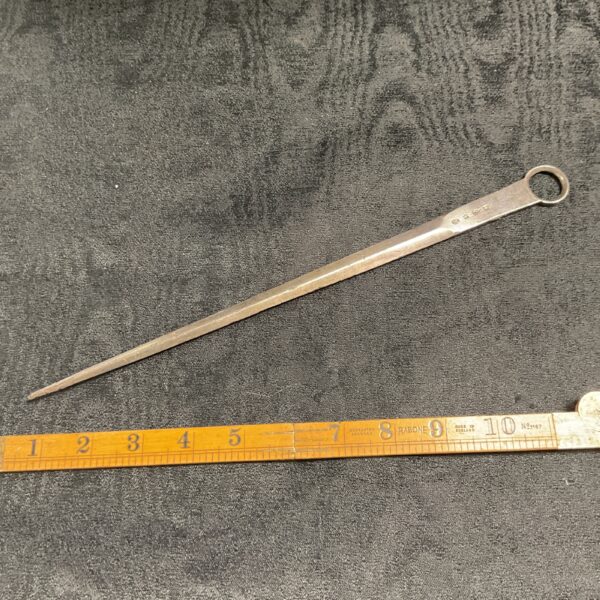 Large stainless steel butchers skewer for preparing meat.