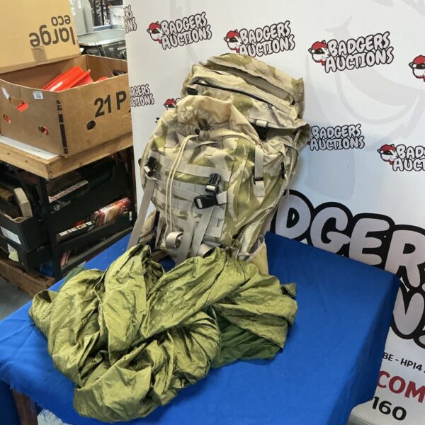 Camouflage rucksack with integrated Mossi net, showing wear.