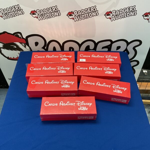 Stack of seven Cards Against Disney game boxes for sale.