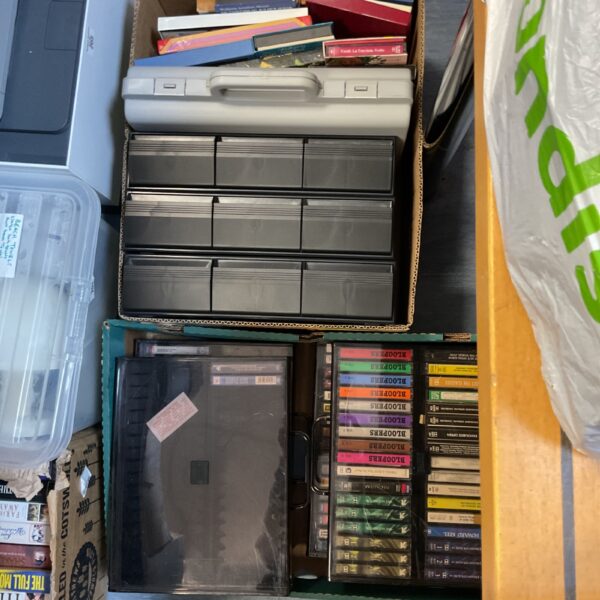 Large collection of vintage cassette tapes in plastic cases.