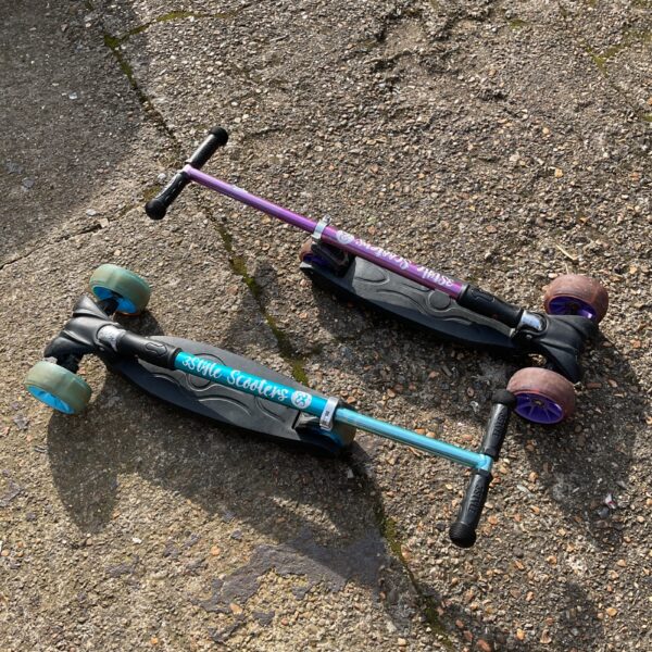 Two colourful childrens scooters in purple and blue.
