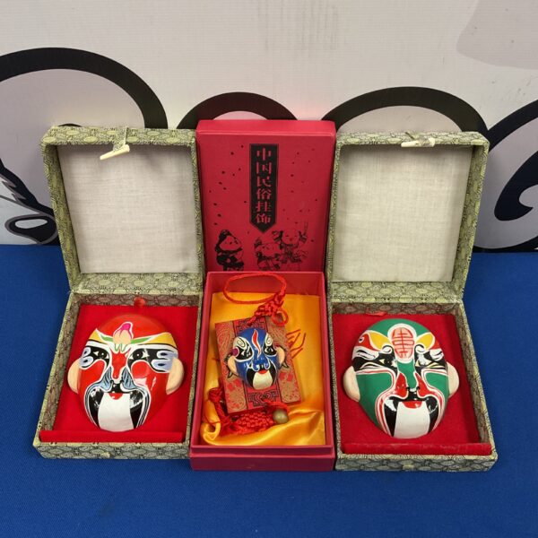 Three miniature Chinese opera masks in presentation boxes.