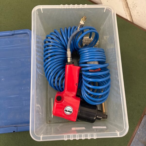 Red Clarke 1/2” air impact wrench with attached air hose.