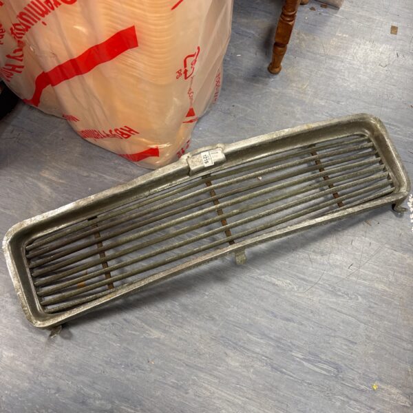 Vintage classic car grill with horizontal bars, showing signs of age.