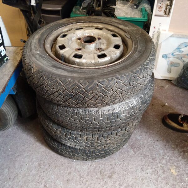 Set of four vintage classic car wheels with steel rims.