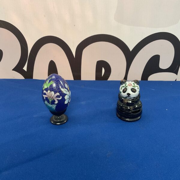 Close-up of vintage cloisonné panda and egg figurines.