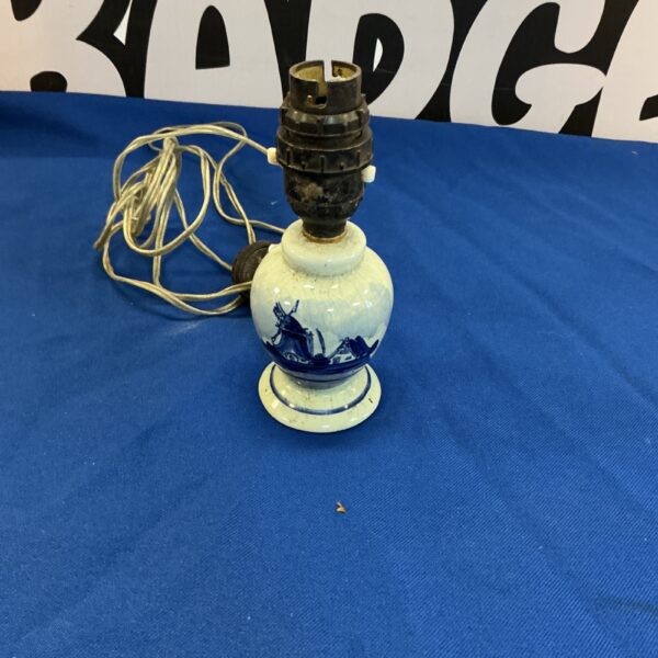 Antique Delft pottery lamp with blue floral pattern.