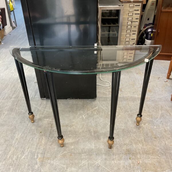 Elegant demi lune console table with glass top and turned legs.