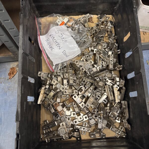 Metal bracket-style door hinges in a plastic container.