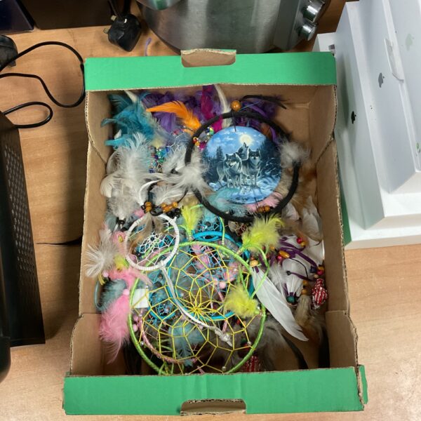 Assorted dreamcatchers with colourful feathers and beads in a box.