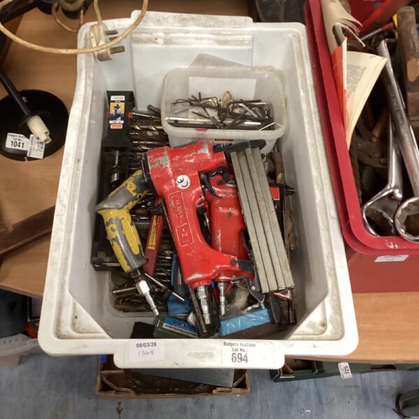 Mixed lot of drill bits, air drill, and staple gun for DIY projects.