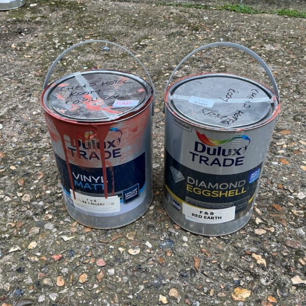 Two Dulux Trade paint tins with handwritten labels.