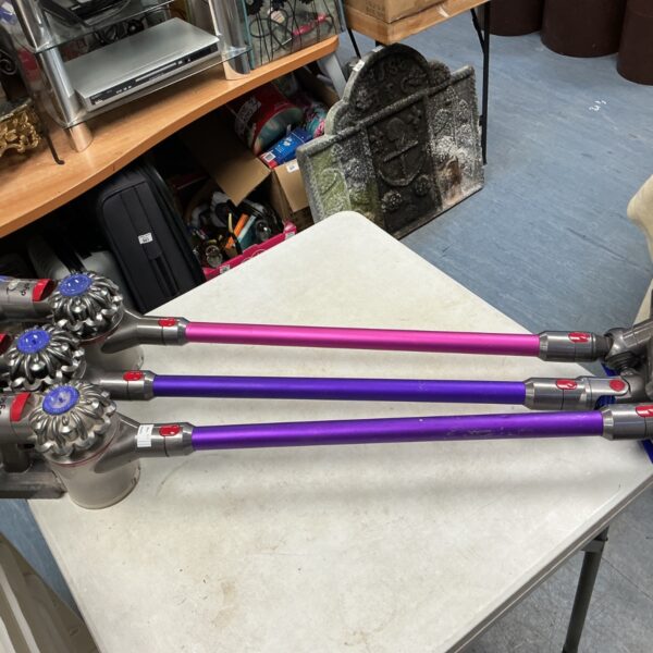 Set of three Dyson cordless hoovers for home cleaning.