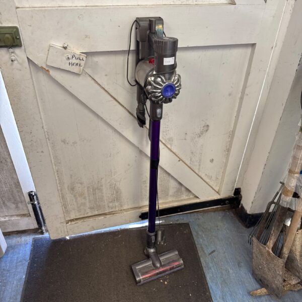 Dyson V8 cordless vacuum cleaner with charging cradle.