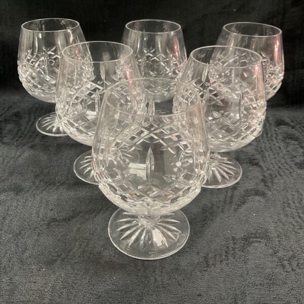 Set of six Edinburgh Crystal brandy glasses on display.