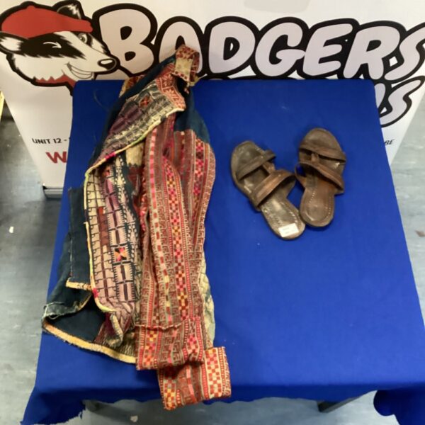 Vibrant hand-embroidered jacket with leather flip-flops, vintage boho style.