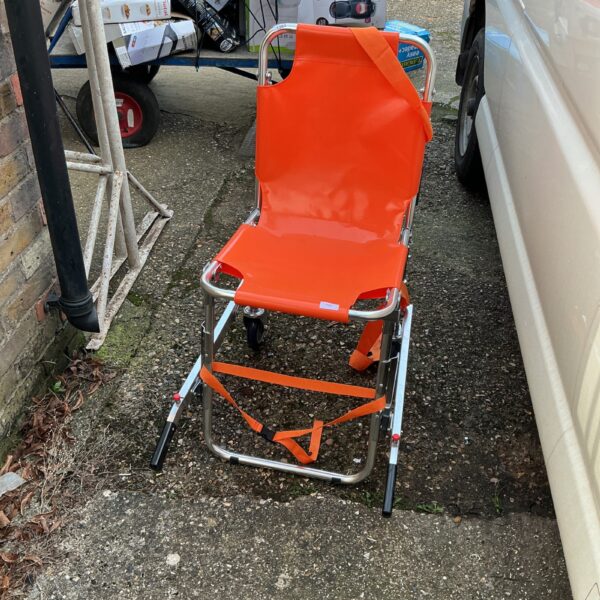 Side view of a used emergency folding wheelchair.
