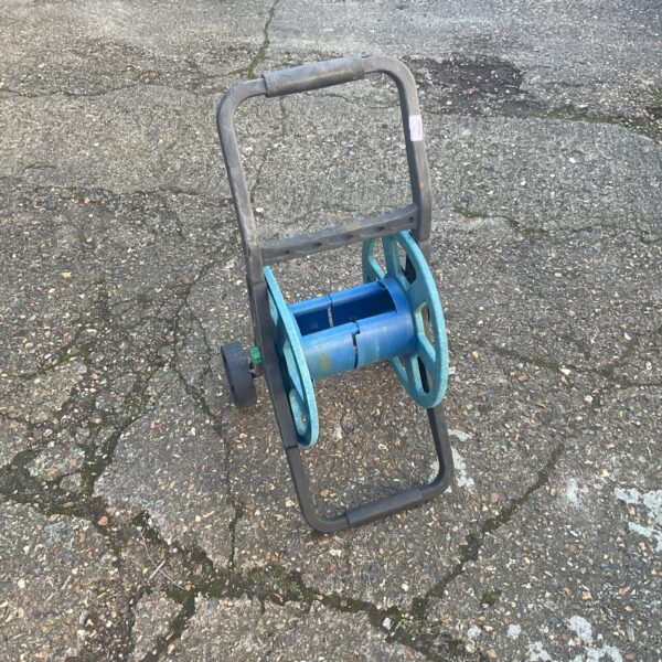Empty plastic garden hose reel for outdoor hose storage.