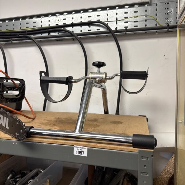 Front view of a vintage exercise pedal machine with adjustable tension.