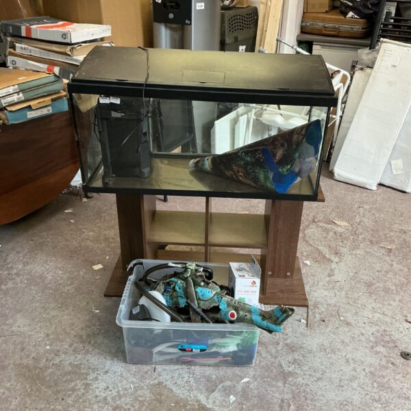 Large fish tank setup with stand and accessories for home aquariums.