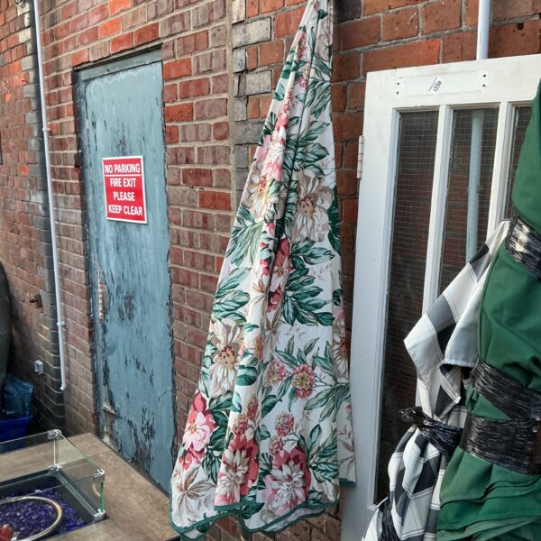 Large floral patio parasol in a garden setting.