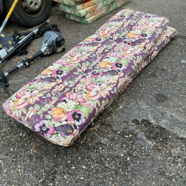 Vibrant floral sunlounger cushions for garden seating.