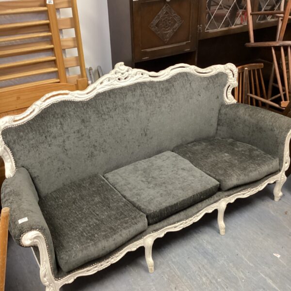 Elegant grey French boudoir sofa with ornate white frame.