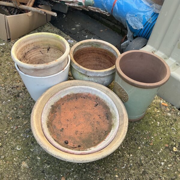 Collection of weathered terracotta garden pots for outdoor plants.