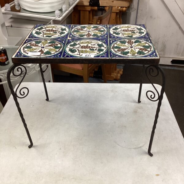 Colourful mosaic tile top garden table with wrought iron legs.